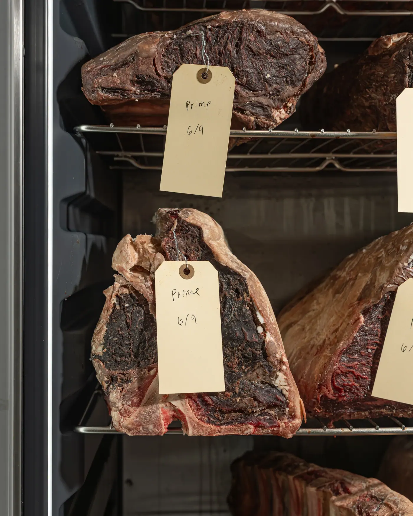 A tagged porterhouse hanging on the rail in the dry-age cellar