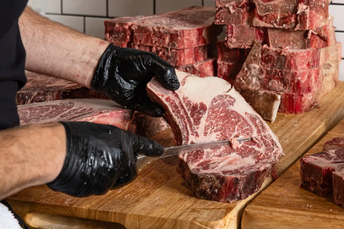 A boneless ribeye being trimmed to spec at the block