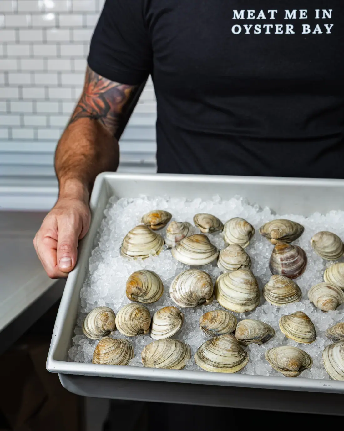 Littleneck clams on ice in a counter tray