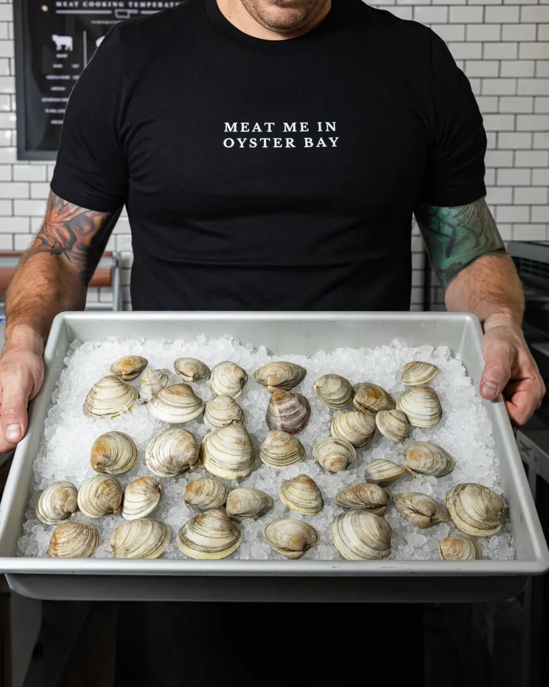 Littleneck clams on ice in a counter tray